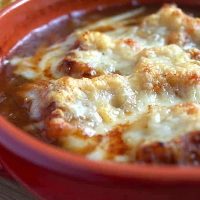 Delicious baked chicken with caramelized onions and melted cheese, perfect for dinner.